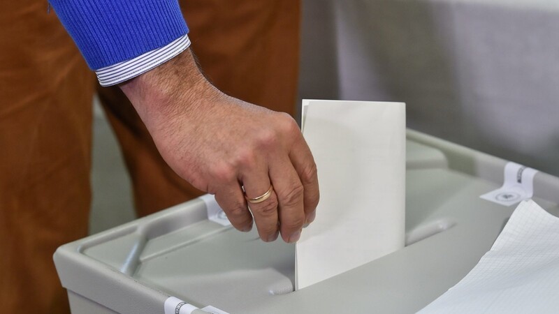 Ein Wähler wirft seinen Stimmzettel in eine Wahlurne in einem Wahllokal.
