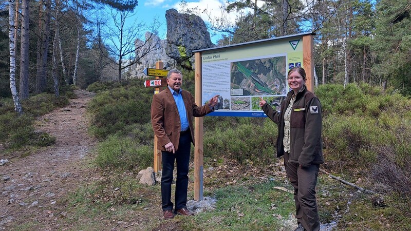 Heinrich Schmidt, Ehrenvorsitzender des Naturparks Bayerischer Wald, und die zuständige Rangerin Katharina Merkel präsentieren die neue Beschilderung am Großen Pfahl.