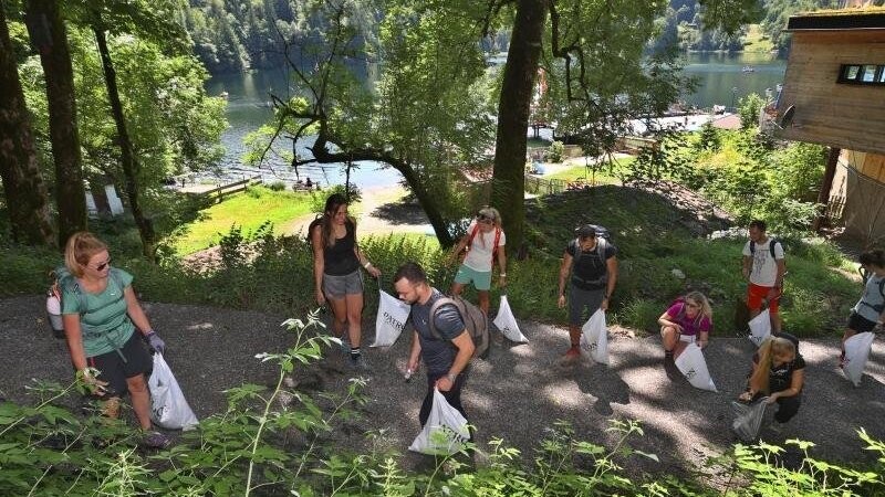 Eine Gruppe von Freiwilligen sammelt auf einem Weg Müll.