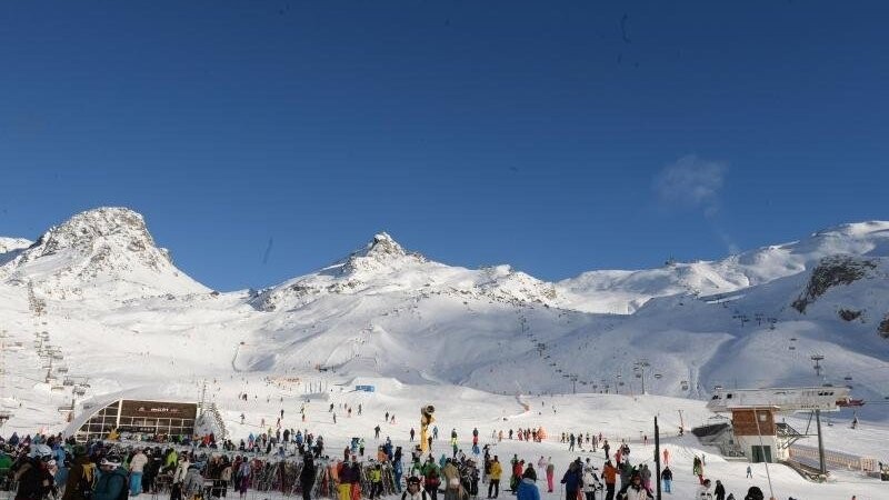 Skifahrer warten bei Sonnenschein an Liften im Skigebiet der Idalp.