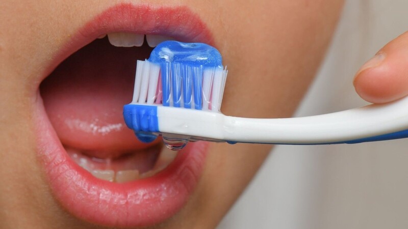 Ein neunjähriges Mädchen putzt sich ihre Zähne mit Zahncreme.