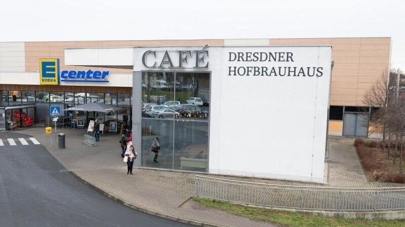 Der Schriftzug "Dresdner Hofbrauhaus" steht an einem Gebäude vor einem Edeka-Supermarkt.