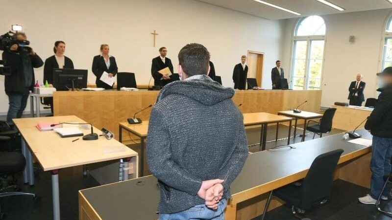 Der Hauptangeklagte (l) steht im Gerichtssaal des Landgerichtes neben zwei Mitangeklagten. Foto: Karl-Josef Hildenbrand/dpa