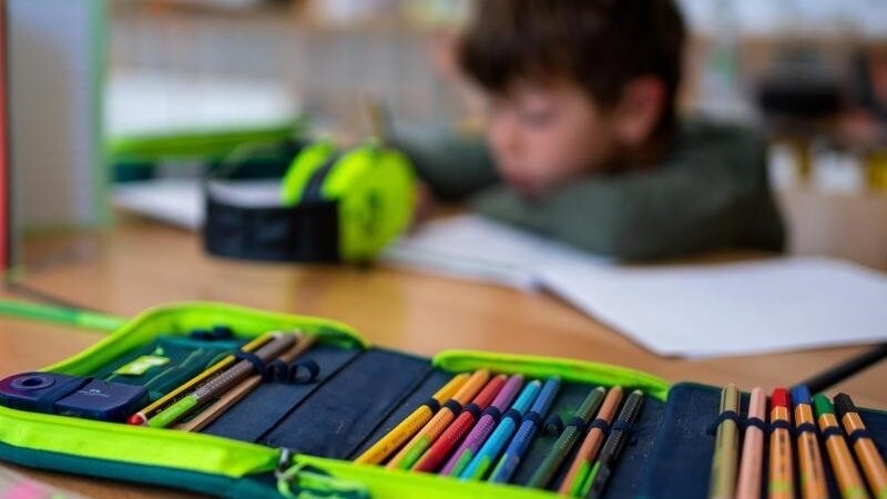 Ein Junge arbeitet in einer Grundschule im Klassenzimmer an einem Arbeitsblatt.