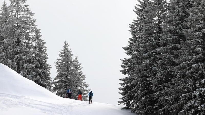Tourengeher durchstreifen die mit Neuschnee bedeckte Landschaft im Skigebiet Grasgehren.