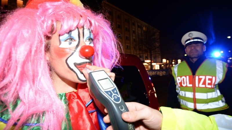 Ein als Clown verkleideter Fastnachtsnarr muss am 20.02.2014 in Freiburg (Baden-Württemberg) bei einer Alkoholkontrolle der Polizei in ein Messgerät pusten.