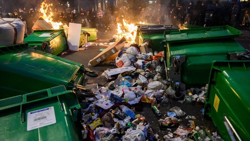 Müllberge brennen in einer Straße. Am Samstag fanden in Paris und darüber hinaus zahlreiche Proteste gegen den Plan von Präsident Macron statt, das Renteneintrittsalter in Frankreich von 62 auf 64 Jahre anzuheben.
