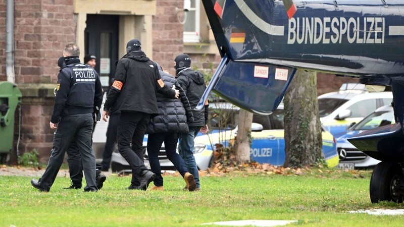 Eine Person (2.v.r.) wird in Karlsruhe von Polizisten aus einem Hubschrauber gebracht.