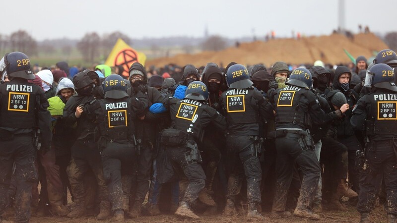 Polizisten drängen Demonstranten am Rande des Braunkohletagebaus bei Lützerath zurück. Vorhergehende Warnungen der Polizei haben Aktivisten ignoriert.