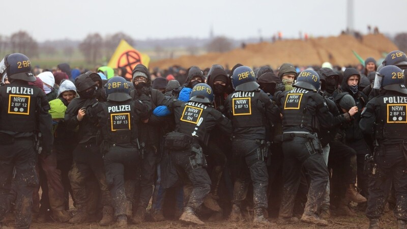 Polizisten drängen Demonstranten am Rande des Braunkohletagebaus bei Lützerath zurück. Vorhergehende Warnungen der Polizei haben Aktivisten ignoriert.