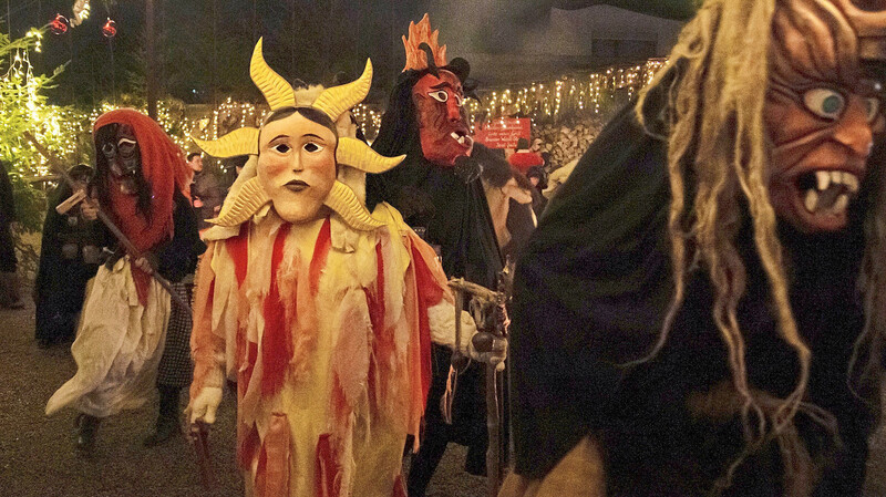 Unheimliche Gestalten besuchen den Adventsgarten in Piflas. Hinter den Masken verbergen sich die Neuhauser Perchten.