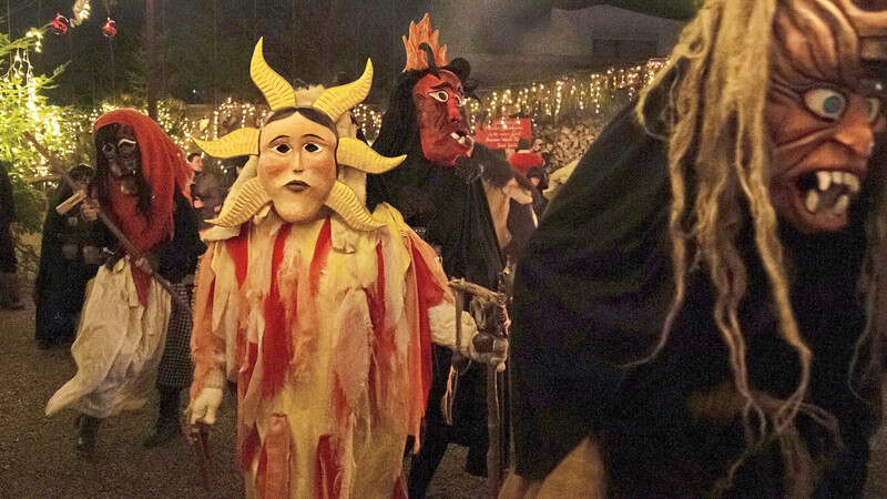 Unheimliche Gestalten besuchen den Adventsgarten in Piflas. Hinter den Masken verbergen sich die Neuhauser Perchten.