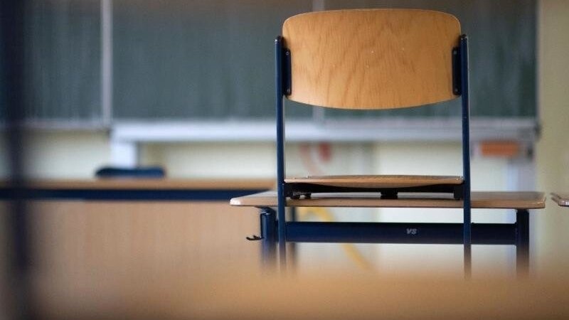 Ein Stuhl steht in einem Klassenzimmer auf dem Tisch.
