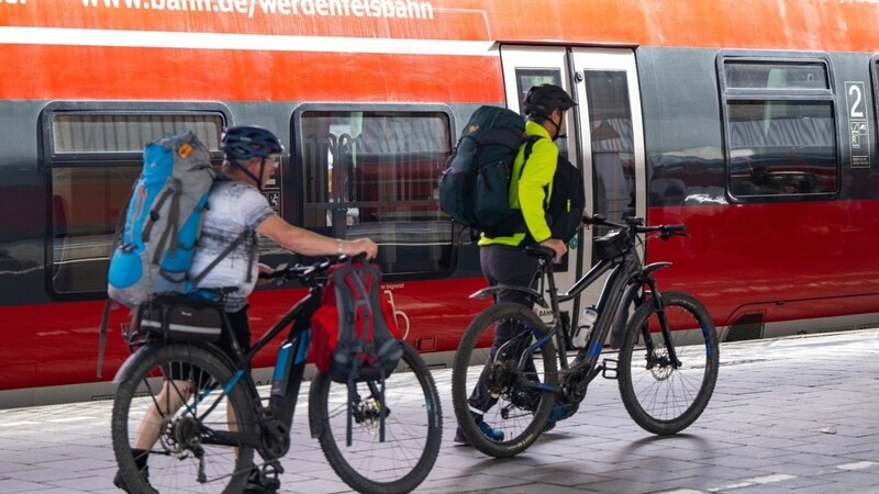 Reisende schieben am Hauptbahnhof in München ihre Fahrräder über den Bahnsteig.