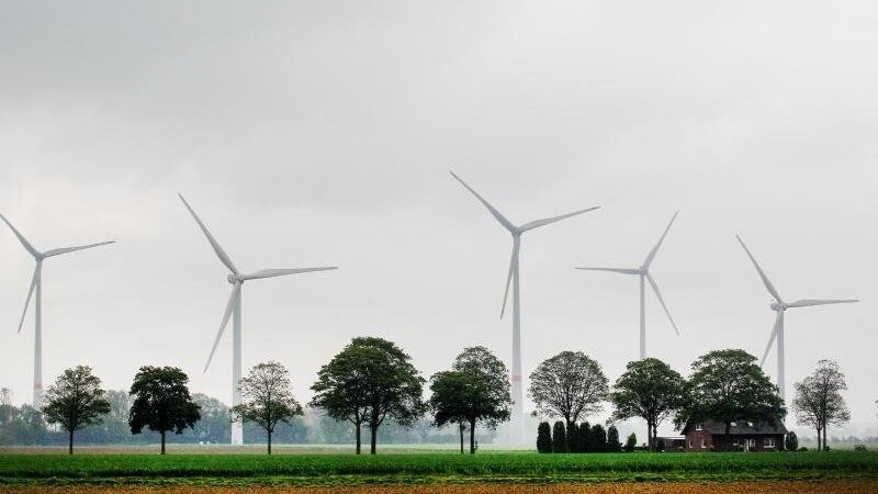 Windkraftanlagen hinter Feldern.
