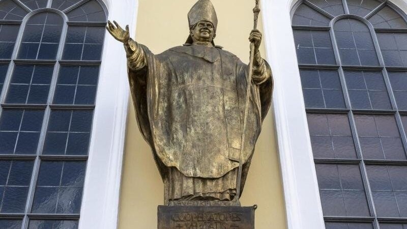 Eine Figur des emeritierten Papstes Benedikt XVI. hängt an einer Fassade im Zentrum der Ortschaft.