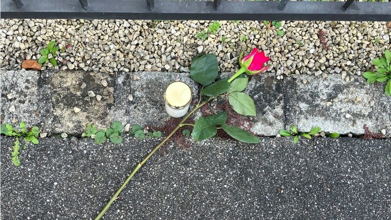 Nach der Bluttat im oberbayerischen Weilheim liegen eine Rose und eine Kerze vor der Gartentür eines Wohnhauses.