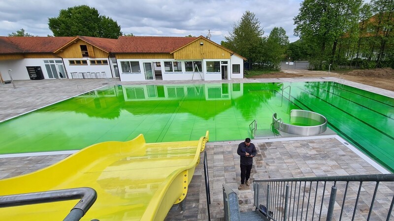 Das Aktivbecken des Freibads Sattelbogen wird mit Lebensmittelfarbe grün gefärbt, um zu sehen, ob frisches Wasser sich im ganzen Becken verteilt.