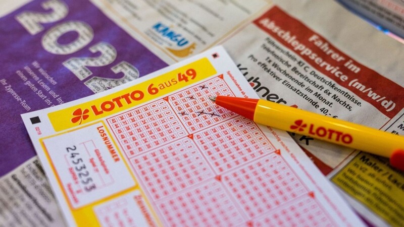 Ein Lottoschein und ein Kugelschreiber liegen in einer Annahmestelle auf dem Tresen.