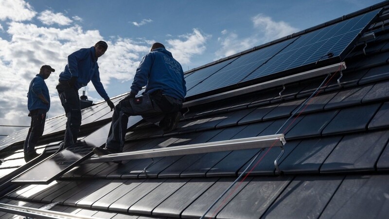 Sonnendächer: Handwerker montieren Photovoltaikmodule auf dem Dach eines Wohnhauses. (Archivbild)