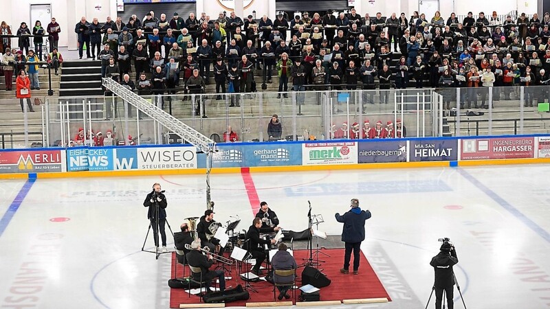 Die Musiker und der musikalische Leiter, Kirchenmusikdirektor Volker Gloßner, hatten sich inmitten der Eisfläche platziert, die Chöre sangen von den Stehtribünen im Eisstadion aus.