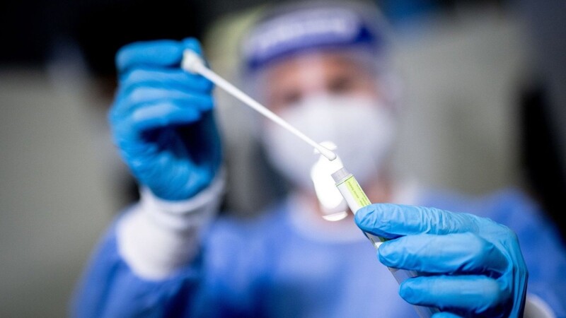 Eine medizinische Mitarbeiterin hält in einem Corona-Testzentrum ein Abstrichstäbchen in der Hand.