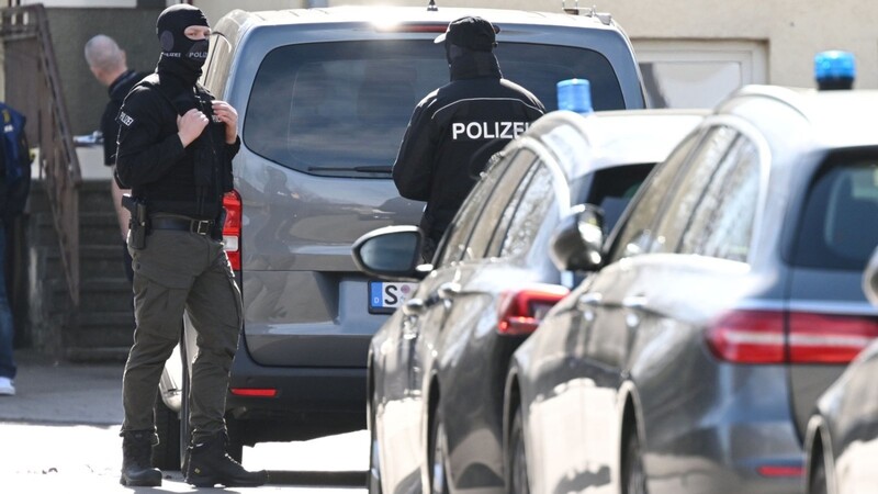 Einsatzkräfte stehen an Einsatzfahrzeugen. Bei einer Durchsuchung im Auftrag der Bundesanwaltschaft ist im baden-württembergischen Reutlingen ein Beamter eines Spezialeinsatzkommandos (SEK) durch einen Schuss verletzt worden.