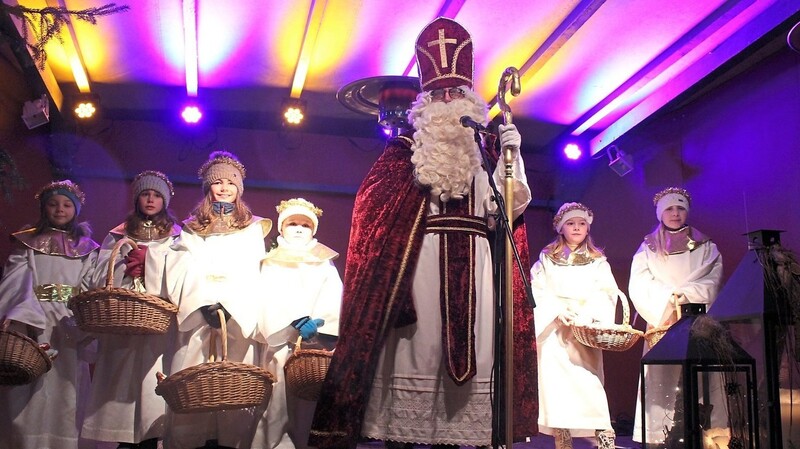 Der heilige Nikolaus und seine fleißigen Engelchen traten am Sonntagabend auf die Christkindlmarkt-Bühne und beschenkten die Kinder, die sich vom Nieselregen nicht hatten abschrecken lassen.