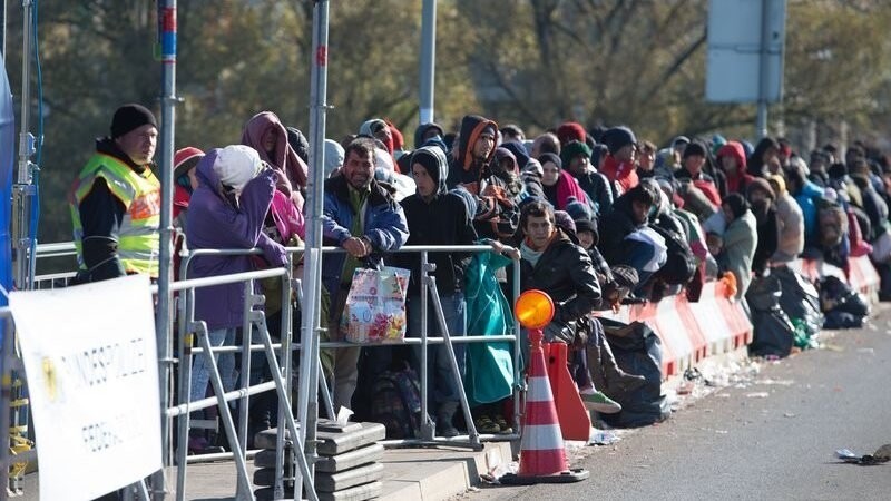 Flüchtlinge warten am 31.10.2015 bei Simbach am Inn (Bayern) an der österreichisch-deutschen Grenze auf der Innbrücke.
