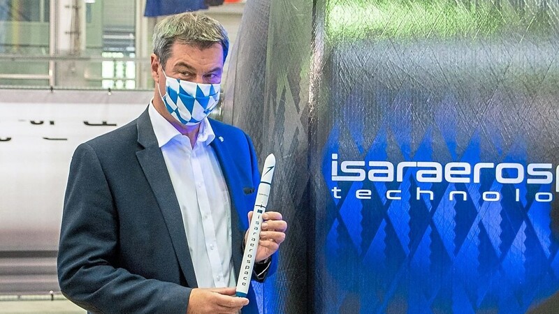 Markus Söder hält eine kleine Rakete in der Hand. Der Ministerpräsident weihte die Produktionshallen des Start-ups Isar Aerospace ein.