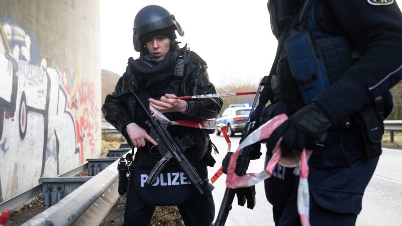 Polizeibeamte sperren die Kreisstraße 22 rund einen Kilometer von dem Tatort entfernt, an dem zwei Polizeibeamte durch Schüsse getötet wurden.