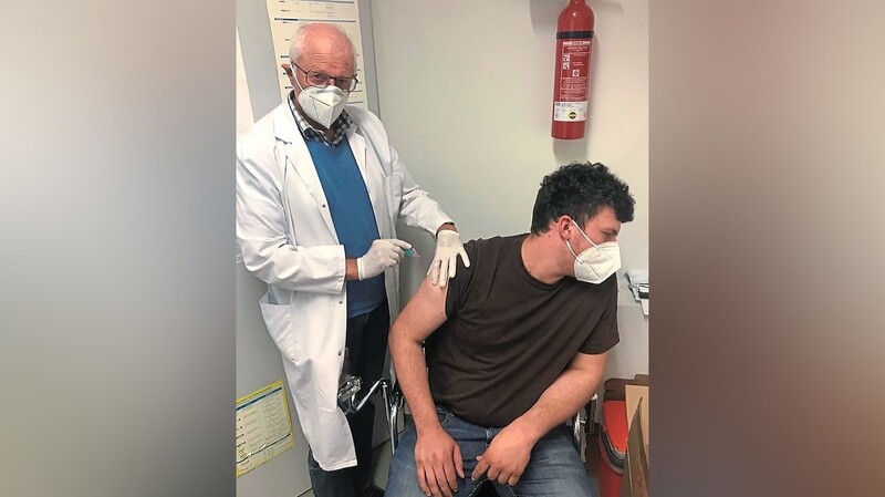 Dr. Georg Mayer impft einen Patienten.