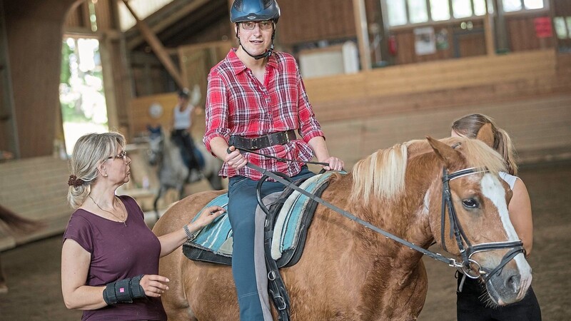 Teresa kommt seit Jahrzehnten in den Reistall. Das Pferd Nathan kennt sie gut. Das Tier sei der eigentliche Therapeut sagt Ursula Wiendl (links), sie selbst sei als menschliche Reittherapeutin nur im Hintgerund tätig.