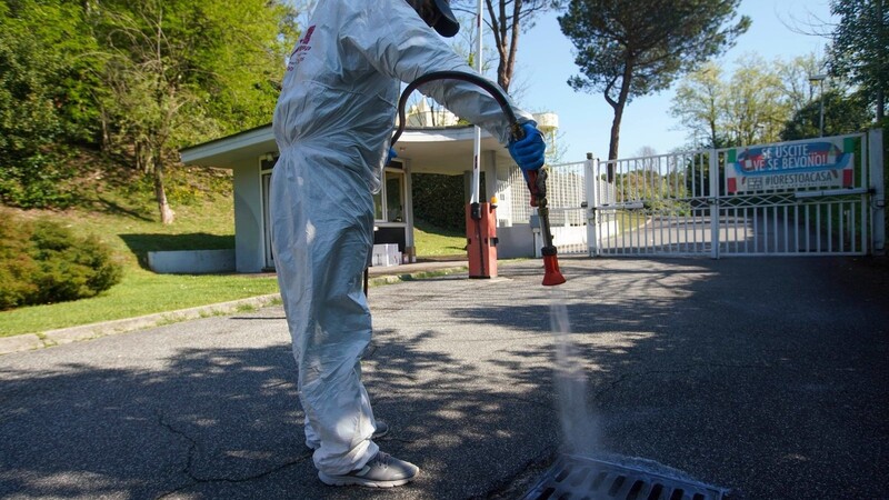 Ein Arbeiter in einem Schutzanzug sprüht Desinfektionsmittel auf ein Kanalisationsgitter in einem Privatviertel der Hauptstadt. Italien bereitet sich wieder auf eine teilweise Wiedereröffnung nach den langen Ausgangsbeschränkungen vor.