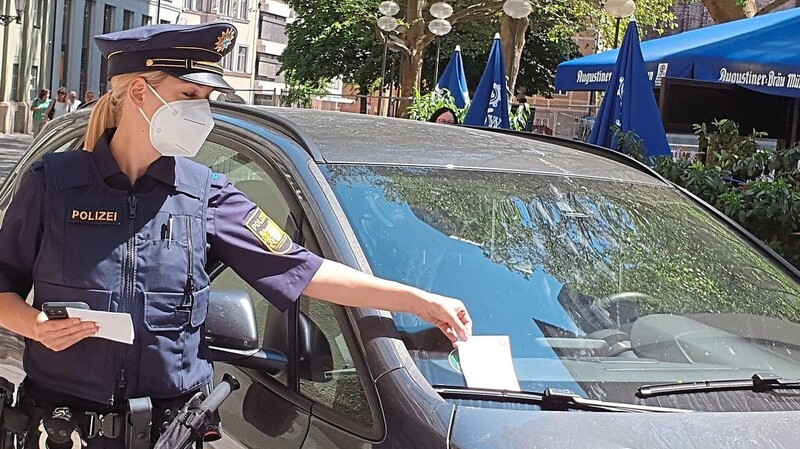 Magdalena Huber stellt die erste Bürgerbenachrichtigung an einem falsch geparkten BMW vor dem Münchner Polizeipräsidium ab.