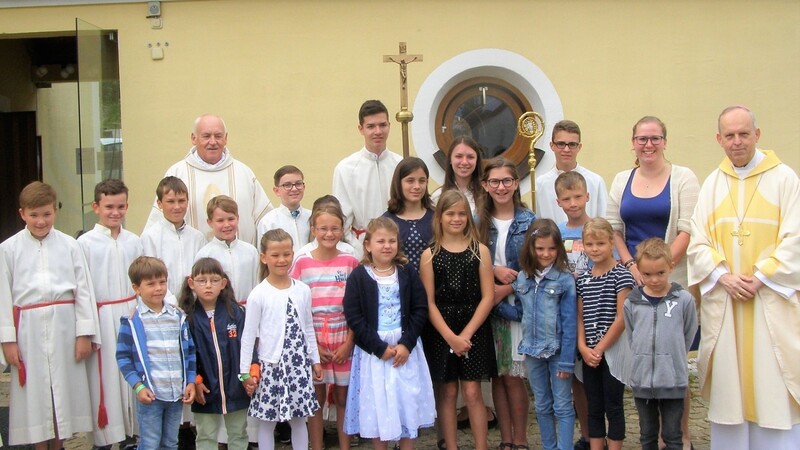 Die Kinder mit Weihbischof Pappenperger, Pfarrer Paulus und den Minis vor dem Einzug in die Kirche.