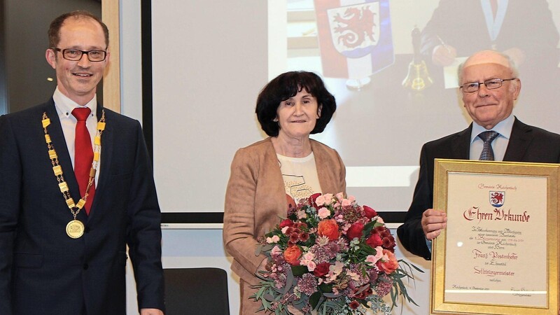 Frischgebackener Altbürgermeister: Franz Pestenhofer (rechts) erhält aus den Händen seines Nachfolgers Bürgermeister Eduard Hochmuth (links) die Urkunde zum Ehrentitel. Herrliche Blumen gab es für Ehefrau Christine.