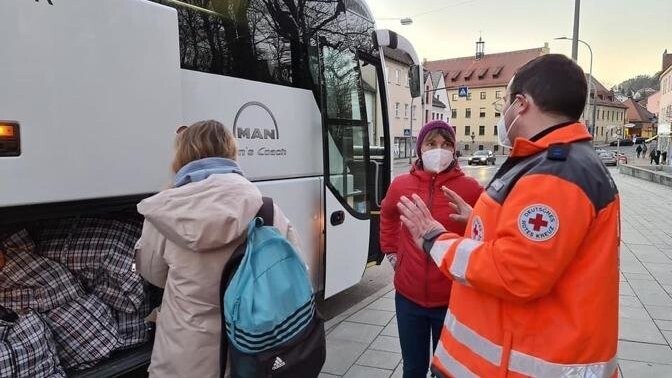 BRK-Helfer nahmen die 33 Geflüchteten am Dienstagabend in Cham in Empfang. Ein Bus hatte sie vom Ankerzentrum in Regensburg nach Cham gebracht.