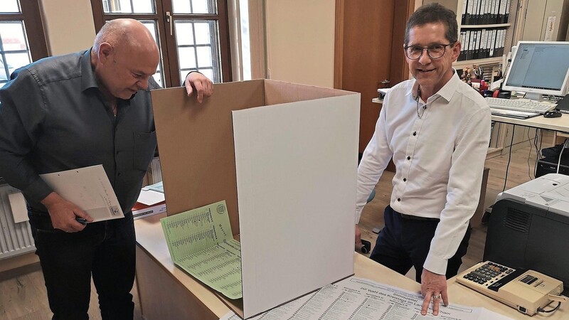 Toni Lauerer (links) und Ludwig Schmidberger zeigen die neuen Wahlkabinenteile aus Pappe, die dem Wähler mehr Platz für die Stimmzettel (grün Stadtrat und weiß Kreistag von vor sechs Jahren) bieten sollen.