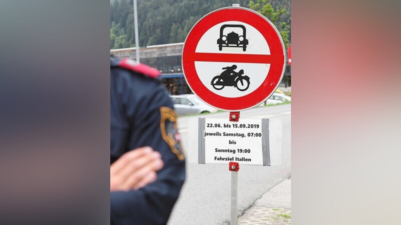 Ein Polizist steht vor einem Schild, das auf die Sperrung für den Verkehr mit Fahrziel Italien hinweist.