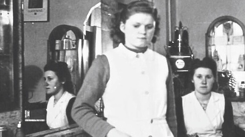 Um 1950: Olga Nothaft als gelernte Friseuse im Lehrbetrieb Sellmeier, Landau. Die Chefin sitzt hinter ihr.