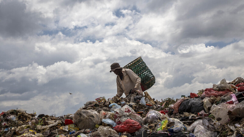 Ein Müllsammler in Indonesien durchsucht eine Müllhalde nach recyclebarem Müll. Hier landen häufig die Überreste aus deutschen, polnischen oder portugiesischen Supermärkten.
