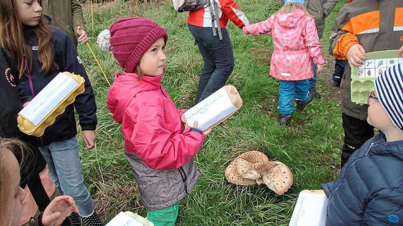 Katrin Wimmer verteilt die Waldforscherbox an die Kinder, die sich rasch mitEicheln, bunten Blättern, Bucheckern, Moosen und Zapfen füllte.