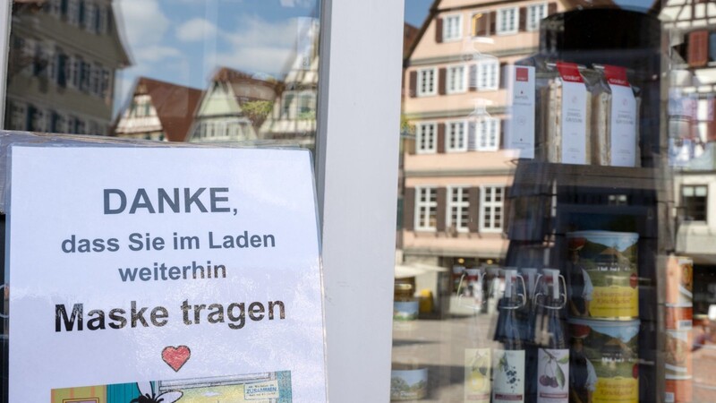 Vor einem Laden in der Innenstadt von Tübingen hängt eine Hinweisschild mit dem die Kunden aufgefordert werden, im Laden auch weiterhin Mund-Nasen-Schutz zu tragen. Bundesweit entfällt die grundsätzliche Maskenpflicht im Einzelhandel.