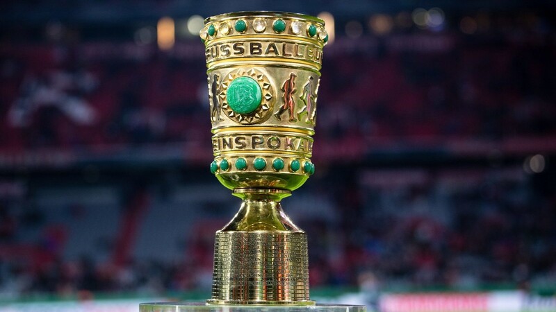 Der DFB-Pokal steht am Spielfeldrand.