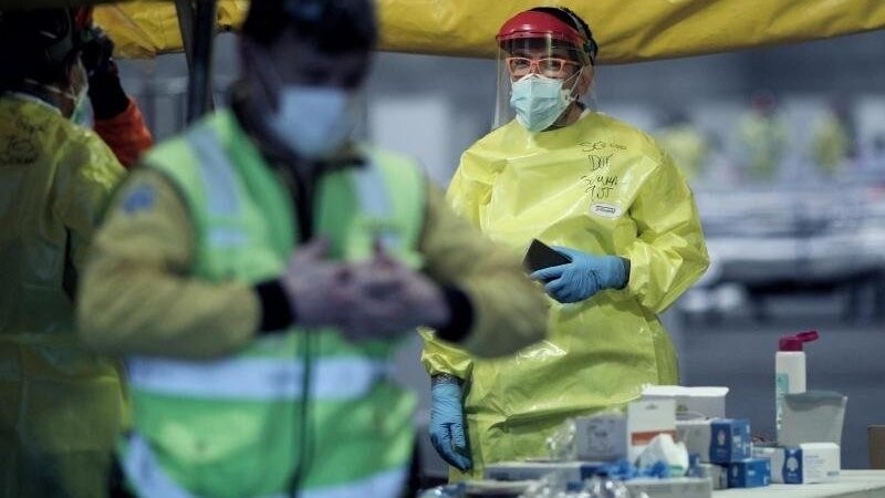 Gesundheitspersonal mit Schutzkleidung auf dem Gelände der Madrider Messe, wo Patienten mit leichten Symptomen behandelt werden.