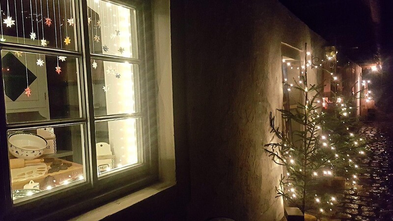 Mit Fröbelsternen geschmückt ist das seit dem zweiten Adventssamstag in der Fensterfront der Hammerschmiede beleuchtete neue Motivfenster mit dem Motto "Kochen anno dazumal".