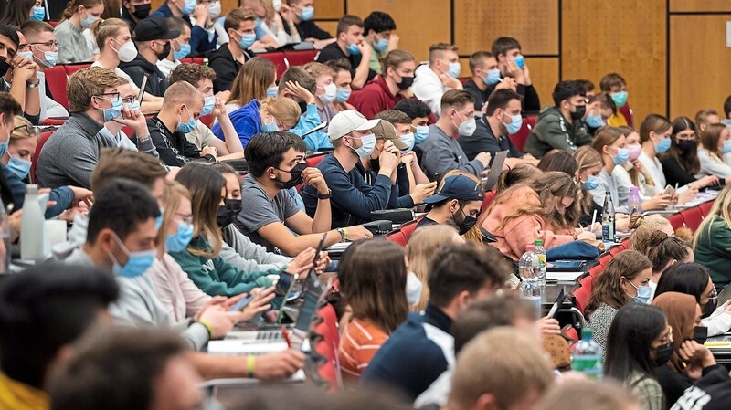 Studenten sitzen in einem vollen Hörsaal. Statt digital finden die Seminare und Vorlesungen in diesem Semester wieder in Präsenz statt.