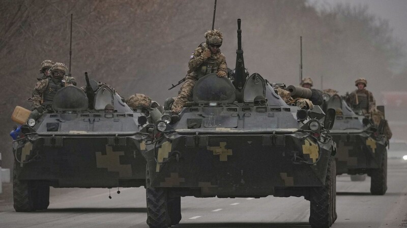 Ukrainische Soldaten sitzen auf gepanzerten Mannschaftstransportern, die auf einer Straße in der Region Donezk in der Ostukraine fahren.