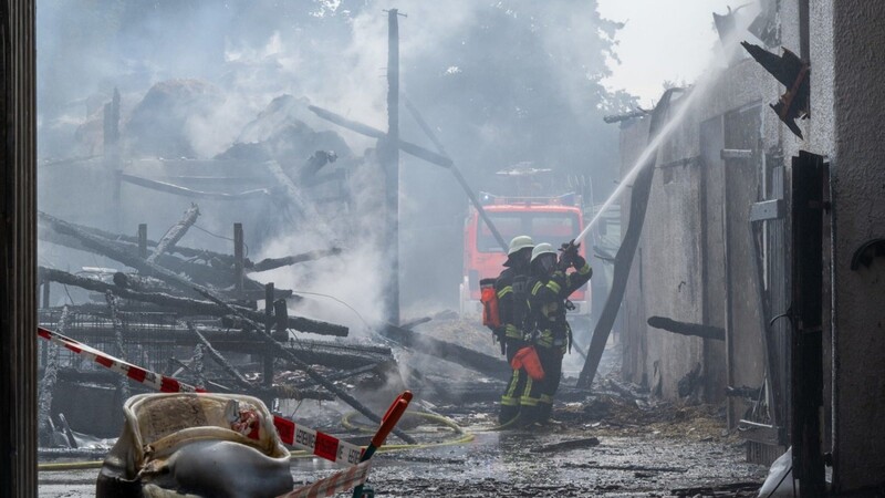 Feuerwehrleute löschen in einem Landwirtschaftlichen Betrieb. Bei einem Brand auf dem Bauernhof mit Biogasanlage wurde auch der Betrieb des Münchner Flughafens gestört.